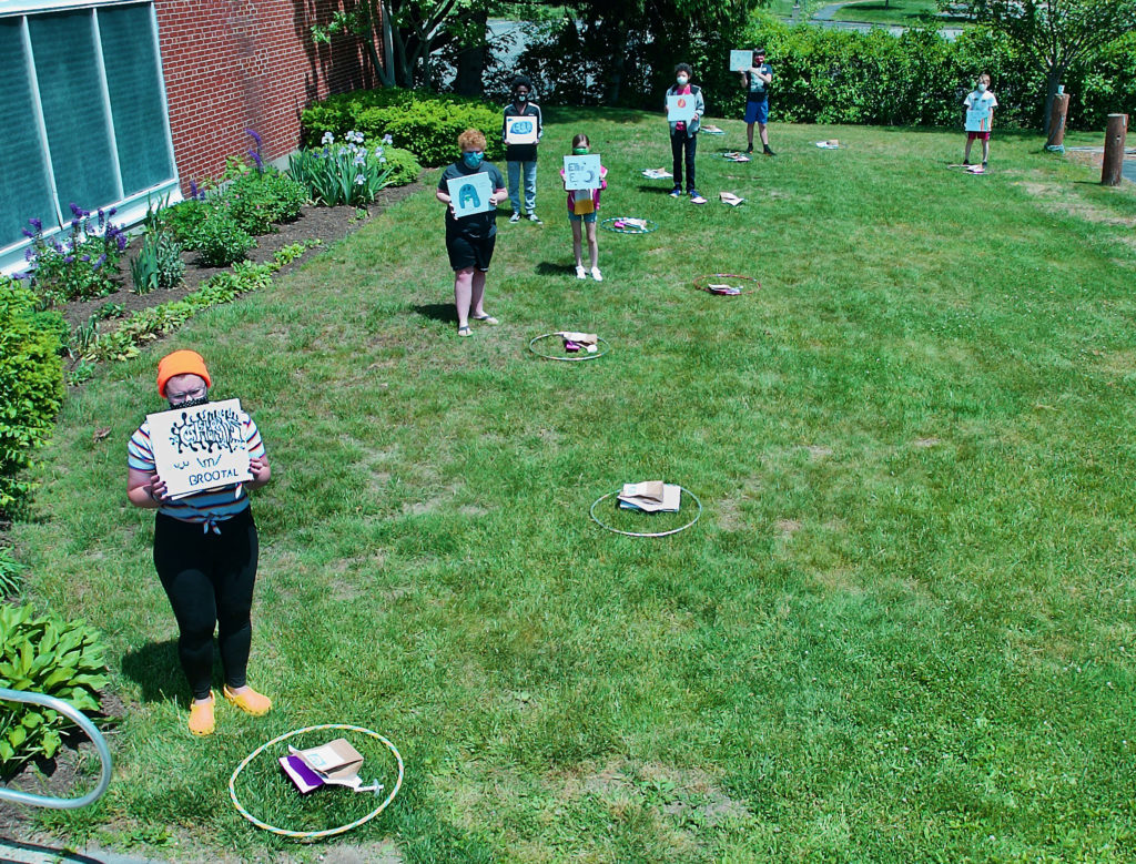 coming of age youth standing apart on the lawn with their scrapbooks