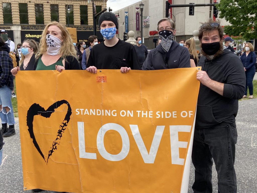 UUCW members holding 'standing on the side of love' banner at city hall protest