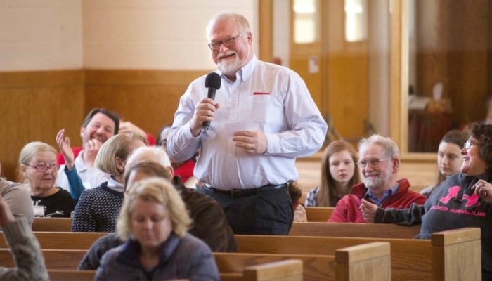 Congregant responds to a question from the minister during a Sunday service.