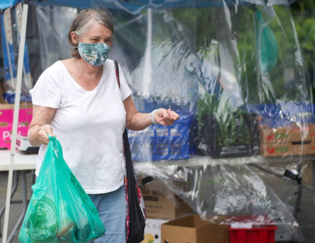Marilyn Raymond shops at the Regional Environmental Council’s Mobile Farmers Market in the UUCW parking lot on Thursday, June 25, 2020, the opening day of the season. 
