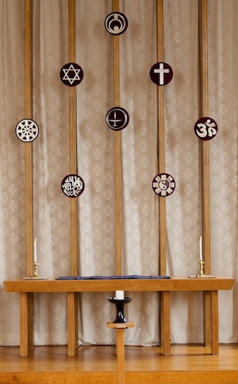 Symbols of a number of world religions adorn the front of the sanctuary